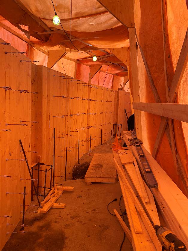 Photo of Inside of the Construction site showing wire hooks on the wall, Orange tarp