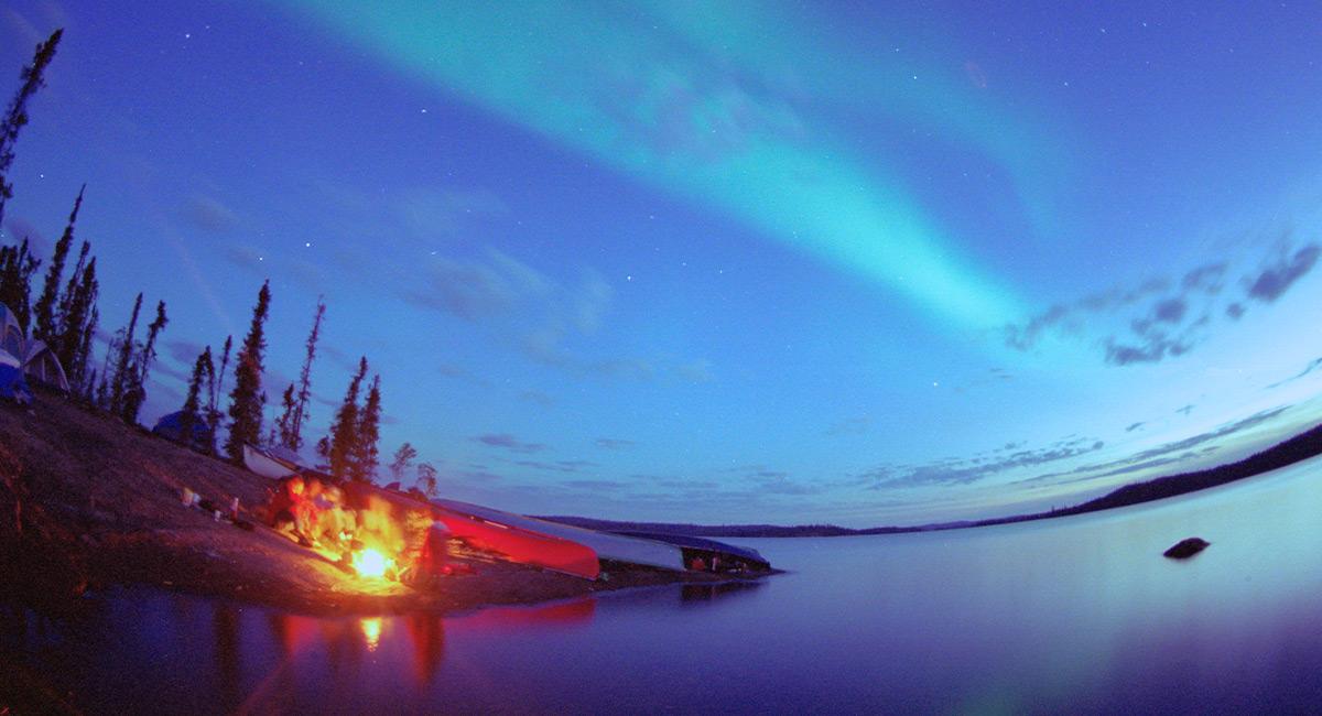 Photo by Tessa Macintosh - Fire on lake under Northern Lights