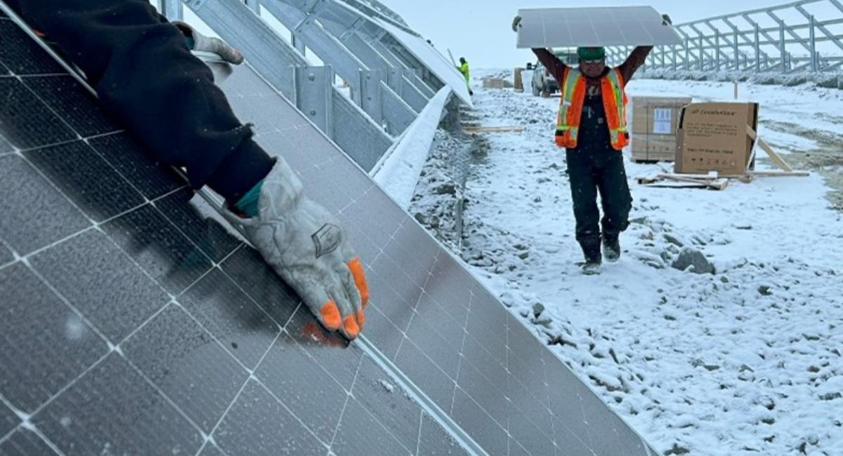 Photo of 3 workers working on Solar Panels in the snow
